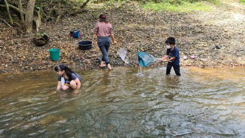 a woman and two children playing in the water at Phu Siab Mhok@KhaoSok in Khao Sok