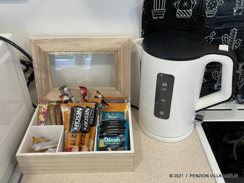 a counter with a coffee pot and a box of food at Penzion Villa Amélie in Mladá Boleslav