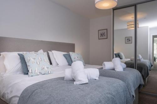Un dormitorio con dos camas con almohadas blancas. en 6 Challacombe - Luxury Apartment at Byron Woolacombe, only 4 minute walk to Woolacombe Beach!, en Woolacombe