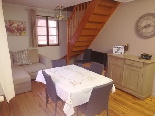 a living room with a table and a couch at O' Bulles du Rosenbourg in Sigolsheim