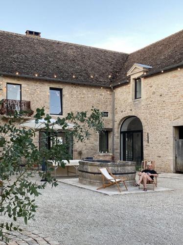 une personne assise sur une chaise devant un bâtiment dans l'établissement Le Clos des Ursulines // Maison seigneuriale du XVIe siècle, à Bligny-lès-Beaune