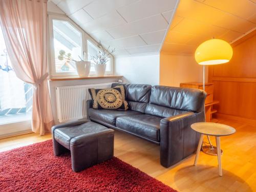 Ferienwohnung Denn في لانغنارغن: غرفة معيشة مع أريكة جلدية وطاولة