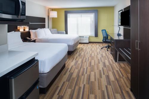 Holiday Inn Express Hotel & Suites Bismarck, an IHG Hotel في بسمارك: غرفة فندقية بسريرين وتلفزيون بشاشة مسطحة