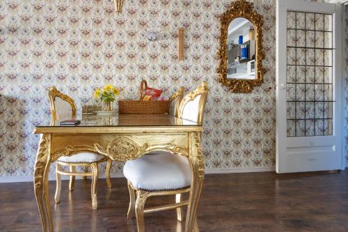 een eetkamer met een tafel met stoelen en een spiegel bij Gold'n Stee in Zeyen