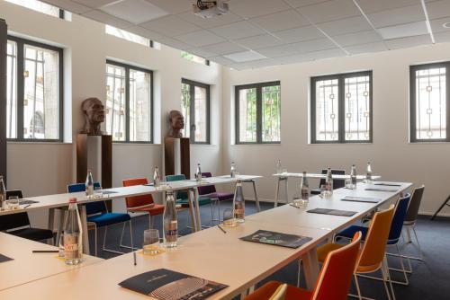a room with tables and chairs and windows at Golden Tulip Saint Malo– Le Grand Bé in Saint Malo