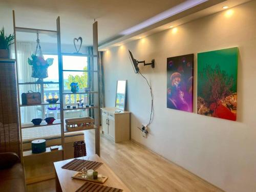 ein Wohnzimmer mit einem Tisch und einem großen Fenster in der Unterkunft Perla Del Mar Studio PANORAMA First line in Lozenets