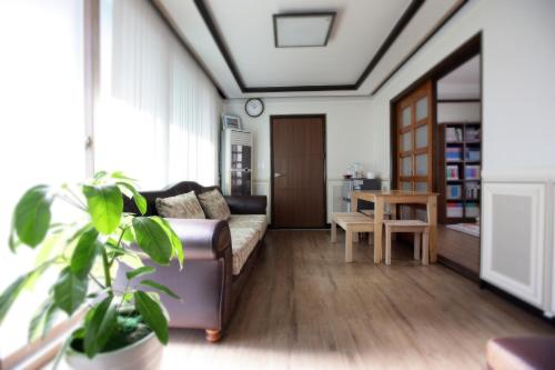 uma sala de estar com um sofá e uma mesa em Green Guesthouse em Gwangju