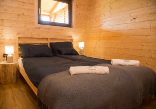 um quarto com 2 camas num chalé de madeira em Sominkowe Wzgórze em Sominy
