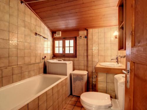 a bathroom with a tub and a toilet and a sink at Gavroche Combles in Verbier