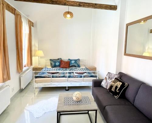 a living room with a bed and a couch at Penzion Villa Amélie in Mladá Boleslav