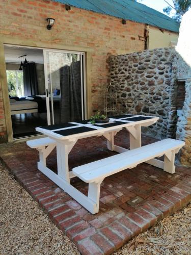 a picnic table and two benches on a brick patio at Welbedacht Game & Nature Reserve in Tulbagh