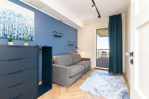 uma sala de estar com um sofá e uma parede azul em New Chic 2-bed at Viru by CentralApartments em Talin