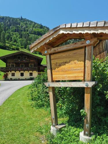 una señal en el costado de una carretera frente a un edificio en Entfeldhof - Familie Schernthaner, en Fusch an der Glocknerstrasse