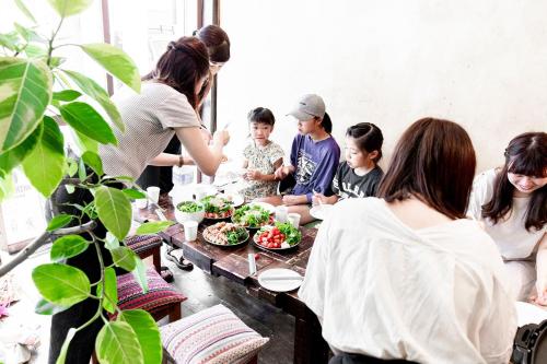 a group of people sitting around a table with food at LovesunshineBackpackers in Tokyo