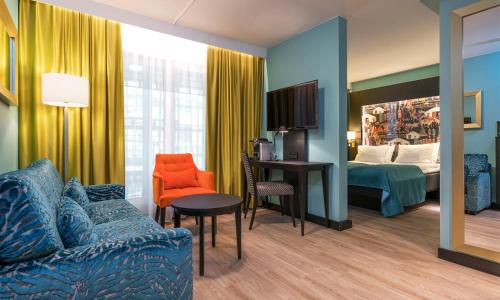 オスロにあるThon Hotel Linneのソファとベッドルームが備わるホテルルームです。
