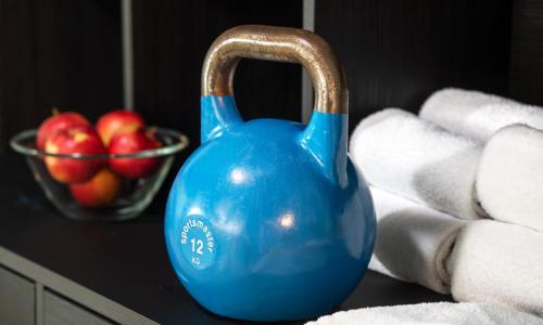 a blue vase sitting on a counter with a bowl of apples at Thon Hotel Linne in Oslo