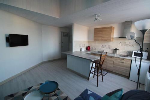 a kitchen with a counter and chairs in a room at STUDIO 12BIS in Aire-sur-lʼAdour