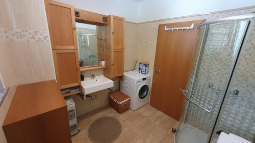 a bathroom with a washing machine and a washer at Apartma Lah in Kobarid
