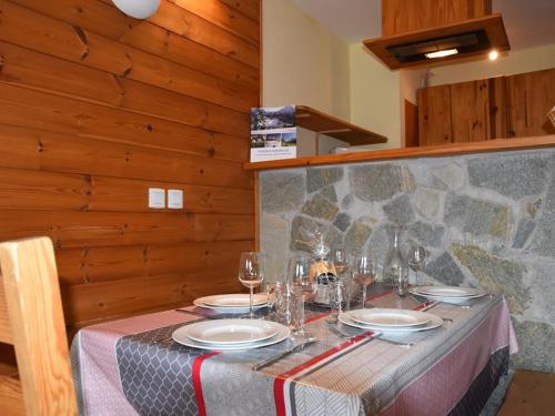 une table avec des assiettes et des verres à vin dessus dans l'établissement Studio avec Parking, Balcon Sud-Ouest et Équipements Complets - FR-1-266-193, à Montgenèvre