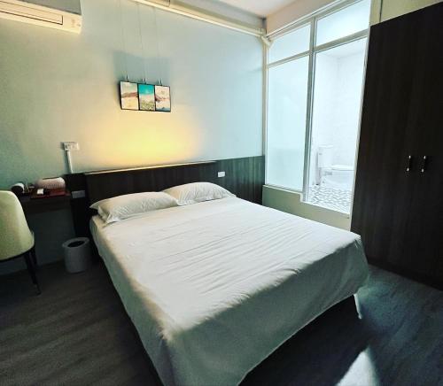 a bedroom with a large bed and a window at ChaoChaoINN in Chaozhou