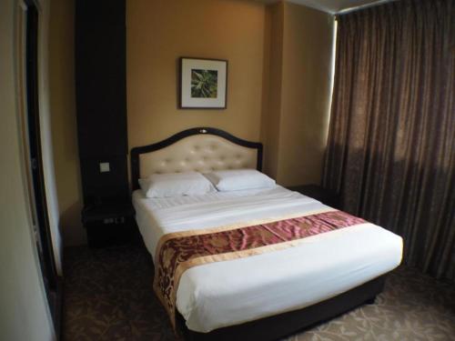 ein Schlafzimmer mit einem großen Bett in einem Hotelzimmer in der Unterkunft L Hotel at Broadway in Singapur