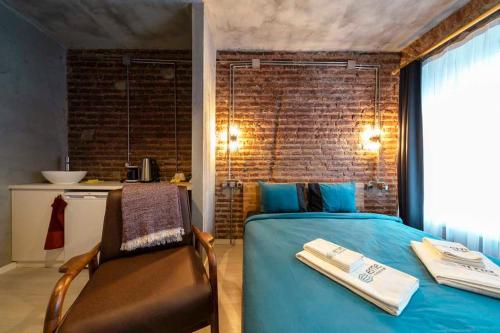 a bedroom with a blue bed and a chair at Classy Furnished Studio in The Heart of Karaköy ( Karakoy 1 ) in Istanbul