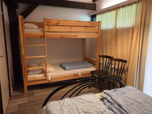 ein Schlafzimmer mit Etagenbetten mit einem Bett und einem Stuhl in der Unterkunft Ferienpark Vorauf in Siegsdorf