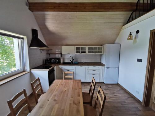 a kitchen with a wooden table and chairs at Apartament Jaśmin in Polańczyk