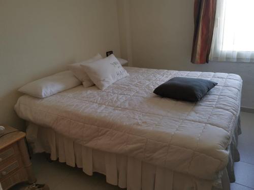 a bed with a black pillow on top of it at Appartment Kristal Mar II in Moraira