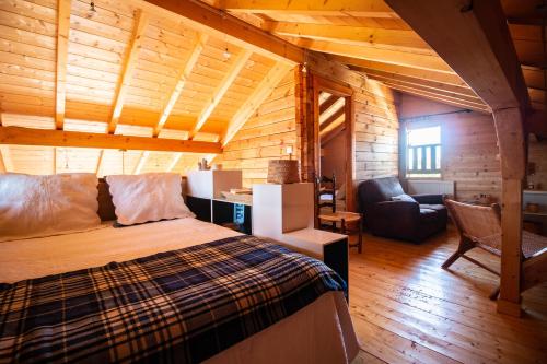 1 dormitorio con 1 cama y 1 sofá en una habitación en Chalet du Bois Joli, en Saint-Laurent-en-Grandvaux