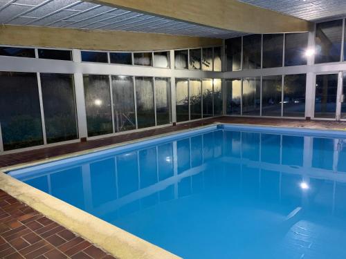 une grande piscine avec de l'eau bleue dans un immeuble dans l'établissement Chalet du Bois Joli, à Saint-Laurent-en-Grandvaux