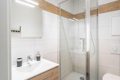 a white bathroom with a shower and a sink at Gemütlich 1 in Wissembourg