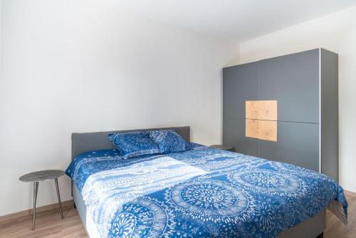 a bedroom with a bed with a blue and white quilt at Gemütlich 1 in Wissembourg
