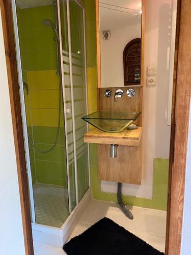 ein Badezimmer mit einem Glaswaschbecken und einer Dusche in der Unterkunft Chez Corinne in Alex