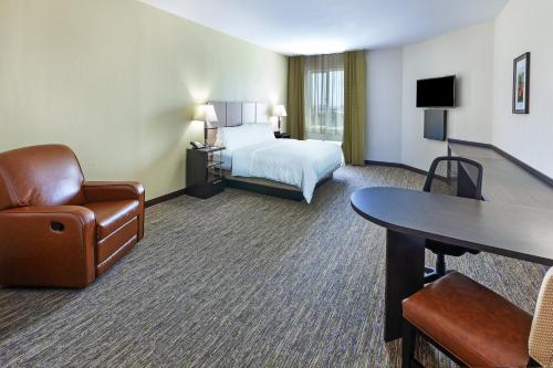 a hotel room with a bed and a desk and chair at Candlewood Suites Houston - Spring by IHG in Houston