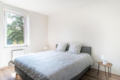 ein weißes Schlafzimmer mit einem großen Bett und einem Fenster in der Unterkunft Gemütlich 4 in Wissembourg