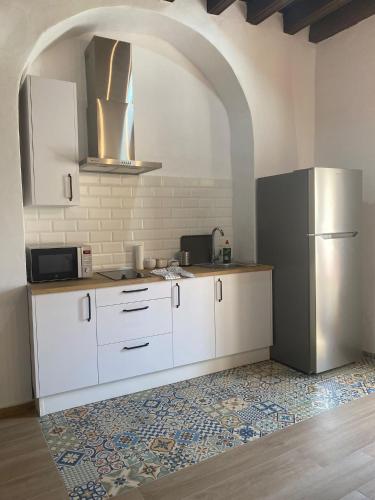 a kitchen with white cabinets and a refrigerator at LA VENDIMIA in Jerez de la Frontera