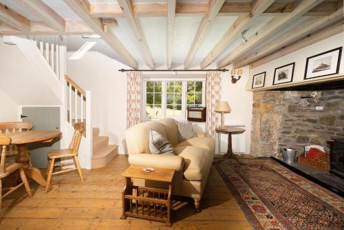 uma sala de estar com um sofá e uma lareira de pedra em Moon Cottage em Newquay