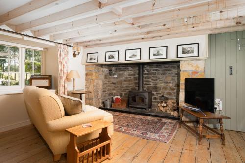 uma sala de estar com um sofá e uma lareira em Moon Cottage em Newquay