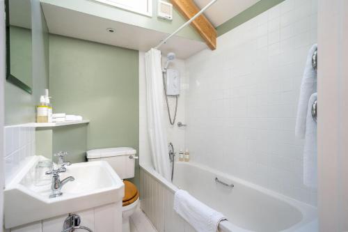 uma casa de banho com um lavatório, uma banheira e um WC. em Moon Cottage em Newquay