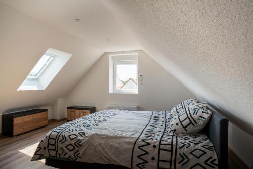 a bedroom with a bed and two windows at Gemütlich 7 - Appartement cosy climatisé in Wissembourg