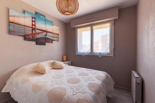 una camera con un letto con due cuscini sopra di Le Golden Gate a Cabourg