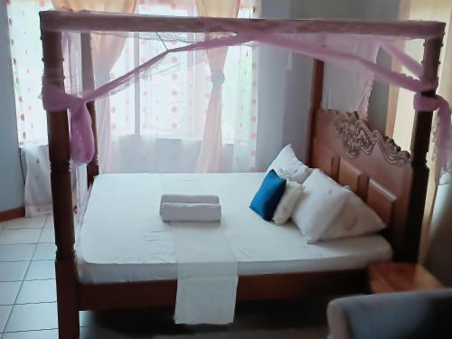 a bedroom with a canopy bed with pillows at Azuri residence homestay in Mombasa