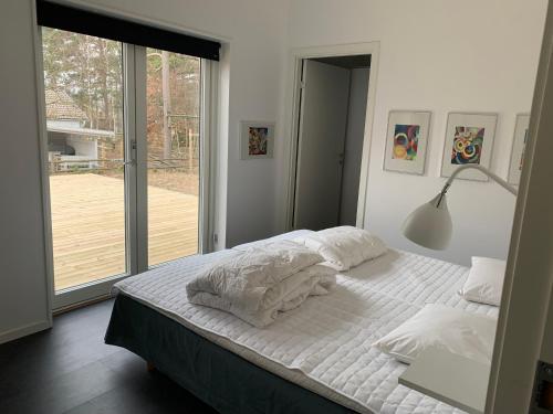 a bedroom with a bed with a lamp and a window at Stugcentralen F-16B in Halmstad