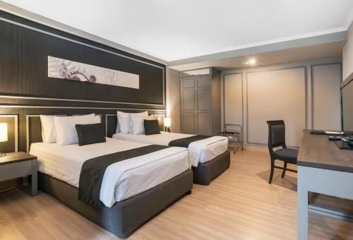 曼谷的住宿－SC Park Hotel，酒店客房配有两张床和一张书桌