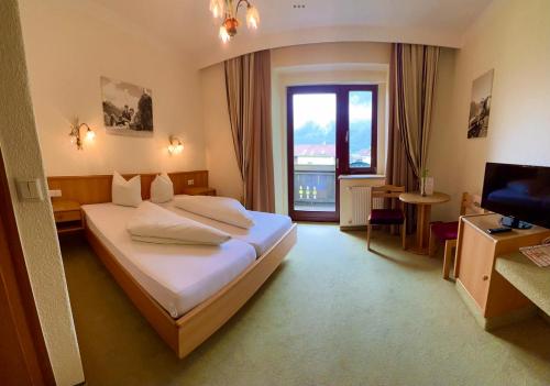 a hotel room with a bed and a television at Hotel zum Lamm in Tarrenz