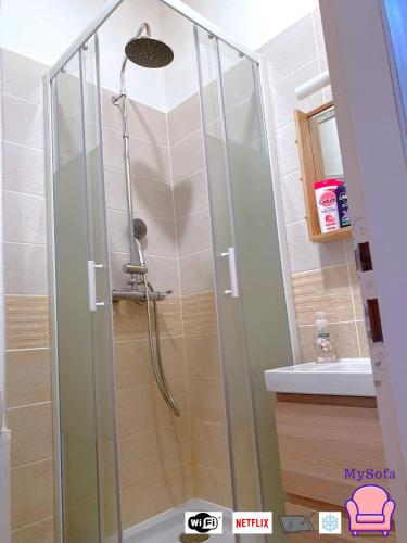 une douche avec une porte vitrée dans une salle de bain dans l'établissement T2 Intra-Muros 