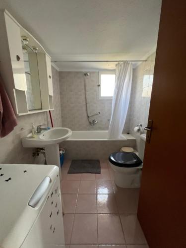 a bathroom with a tub and a toilet and a sink at Hidden Gem Apartment in Neoi Epivates