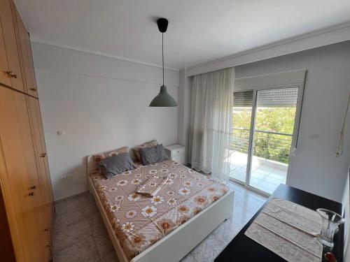 a bedroom with a bed and a sliding glass door at Hidden Gem Apartment in Neoi Epivates