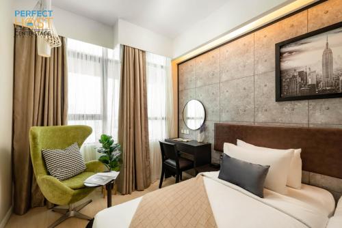 a hotel room with a bed and a desk at Centrestage Petaling Jaya by Perfect Host in Petaling Jaya